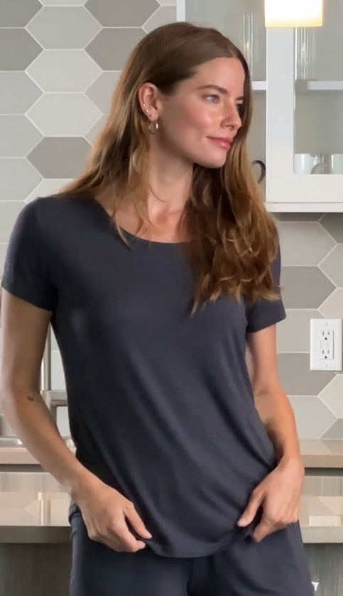 Woman wearing a dark charcoal gray bamboo T-shirt and matching shorts lounge set